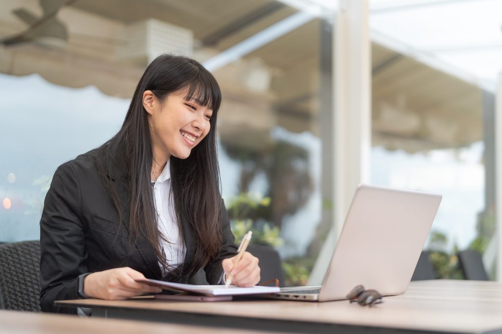 Business Asian woman working on computer in cafe outdoor