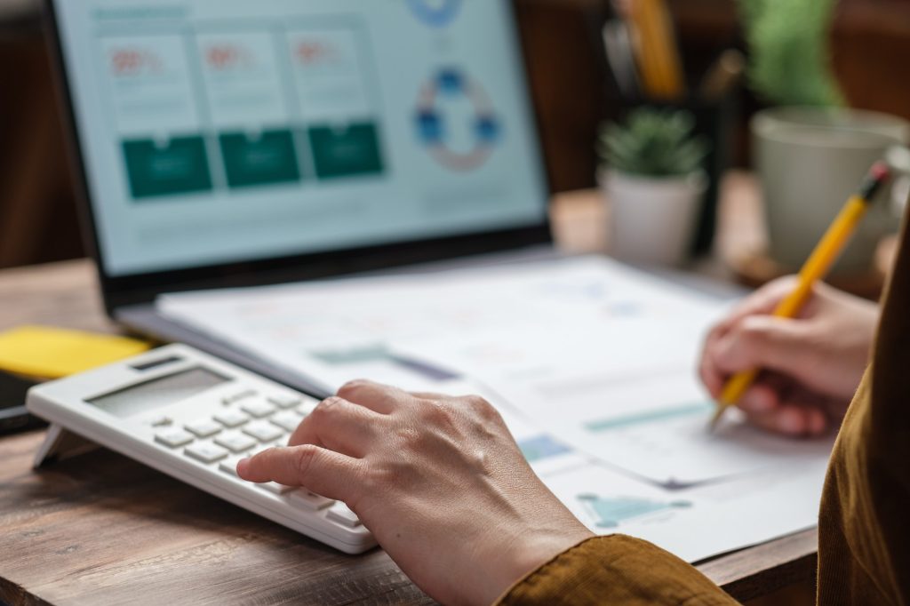 close up hand using calculator calculate tax and budget of project at home